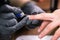 Close-up professional beautician hands working with electric drill on client fingernails. Procedure applying artificial