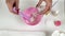 Close up of Professional beautician makes a white clay mask, she mixes it a pink bowl