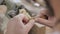 Close-up of a professional carpenter polishing a wooden part with leather on a lathe