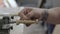 Close-up of a professional carpenter polishing a wooden part with leather on a lathe