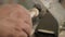 Close-up of a professional carpenter using sandpaper to grind a piece of wood on a lathe