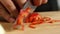 Close-up of professional chef slicing sweet peppers. Stock footage. Restaurant`s chef professionally slices sweet red
