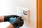 Close up of a professional cleaner cleaning a modern light switch and dimmer and socket