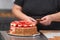 Close up of Professional confectioner making a delicious cake in the pastry shop.