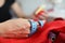 Close-up of professional dressmaker holding blue tape measure