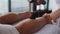 Close-up of professional male masseur massaging calf muscles of muscular sportsman with massage percussion device on