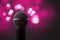 Close up of a professional microphone with pink blurred lights i