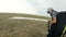 Close-up professional paraglider pilot prepares for takeoff, buttoning equipment and straightening slings