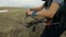 Close-up professional paraglider pilot prepares for takeoff, buttoning equipment and straightening slings