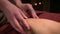 Close-up Professional sports hip massage. A male masseur massages a male athlete in a room with dimmed light against the