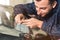 Close-up of a professional windshield repairman fills a crack in the glass with a special polymer through a syringe