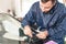 Close-up of a professional windshield repairman working with hydraulic polymer crack filler. Elimination of cracks and