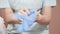 Close-up Professional woman beautician puts on her hands blue rubber clean sterile gloves before doing the procedure for