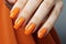 A close-up of a professionally done orange manicure