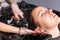 Close up profile view of young beautiful woman having hair washed and rinsed by stylist