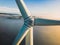 Close-up on the propellers of a wind turbine during a misty morning and sunrise.