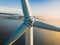 Close-up on the propellers of a wind turbine during a misty morning and sunrise.