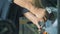 Close up of prosthetic hands sharpening a knife with a lathing mechanism