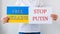 close up of a Protester hands holding cardboard Banner with the words stop putin free ukraine