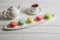 Close up. Provence breakfast. Colorful pastry macarons laid out on an oblong plate, a cup of berry tea, a teapot
