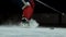 Close-up of the puck is on the ice and in slow motion hockey player pulls up and the snow flies into the camera and he