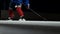 Close-up of the puck is on the ice and in slow motion hockey player pulls up and the snow flies into the camera and he