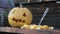 Close-up of a pumpkin and a lantern Jack lying on the table, next to cutting vegetables. Next to the knife sticks with a