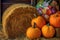 close-up of pumpkins with colorful leaves and hay bales