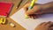 Close-up pupil's hands doing math in a notebook.