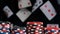 Close-up, pyramid of multi-colored chips, for playing poker, on a black background and flying cards