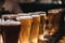 Close up of a rack of different kinds of beers, dark to light, on a table.