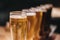 Close up of a rack of different kinds of beers, dark to light, on a table.