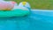 CLOSE UP: Rain drops fall into the empty turquoise water and colorful floaties.