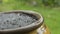 Close up the rain falling into a clay jar. Selective focus.