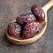 Close up Ramadan concept Wooden spoon with Medjool dates, highly nutritious