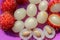 Close up of rambutan, whole and peeled fruits. Top view Healthy fruits on purple background. Ready to Eat Sweet Bali Fruit. Fruit