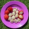 Close up of rambutan, whole and peeled fruits. Top view Healthy fruits on purple background. Ready to Eat Sweet Bali Fruit. Fruit