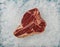 Close up raw beef T bone steak on crushed ice
