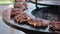 Close-up of raw chicken meat on the round barbecue. Street food