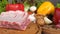 Close-up of raw foods ready to be cooked. Still life with meat and vegetables. Wooden board as a background,