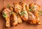 Close up of Raw marinated chicken drumsticks on grill grid with ingredients