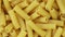 Close-up of raw penne pasta, texture or background, italian design.