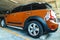 Close-up of Rear light or Tail lamp, Wheel and Door of beautiful shiny brown mini cooper parked in the parking lot