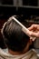 close-up rear view of male head with wet hair and hand of barber accurate combing hair