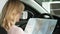 Close up rearview shot of a female driver using a map in her car