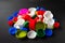 Close-up of recycled plastic bottle caps. Colored PET caps on a black background. Separate garbage collection. Recycling of