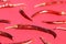 Close up of Red Arbol Chili Peppers scattered on red background.