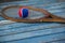 Close up of red and blue ball on wooden tennis racket