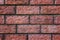 A close up of a red bricked wall. Bricky texture. Brickwork jointed background. Seams of a brick wall. Blocks of bricks in fence c