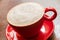Close-up of red coffee mug with frothed milk